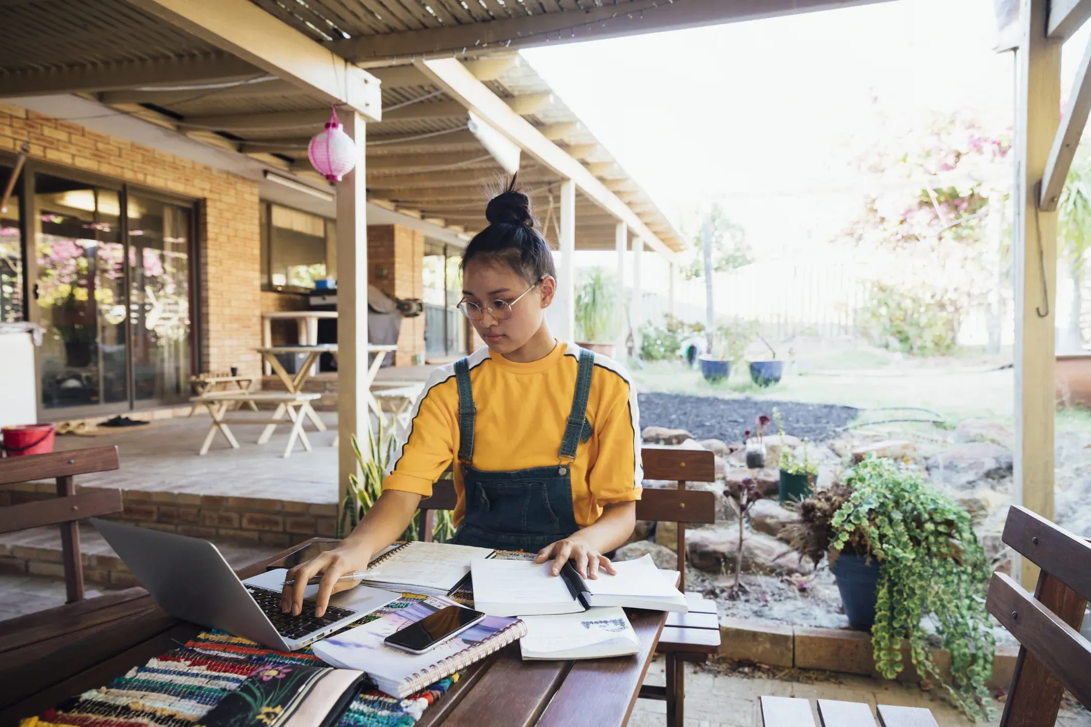 female student studying at a table outside