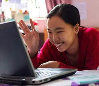 Teenage girl waving to and interacting with someone online