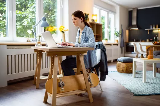 Female student at desk with laptop and skateboard