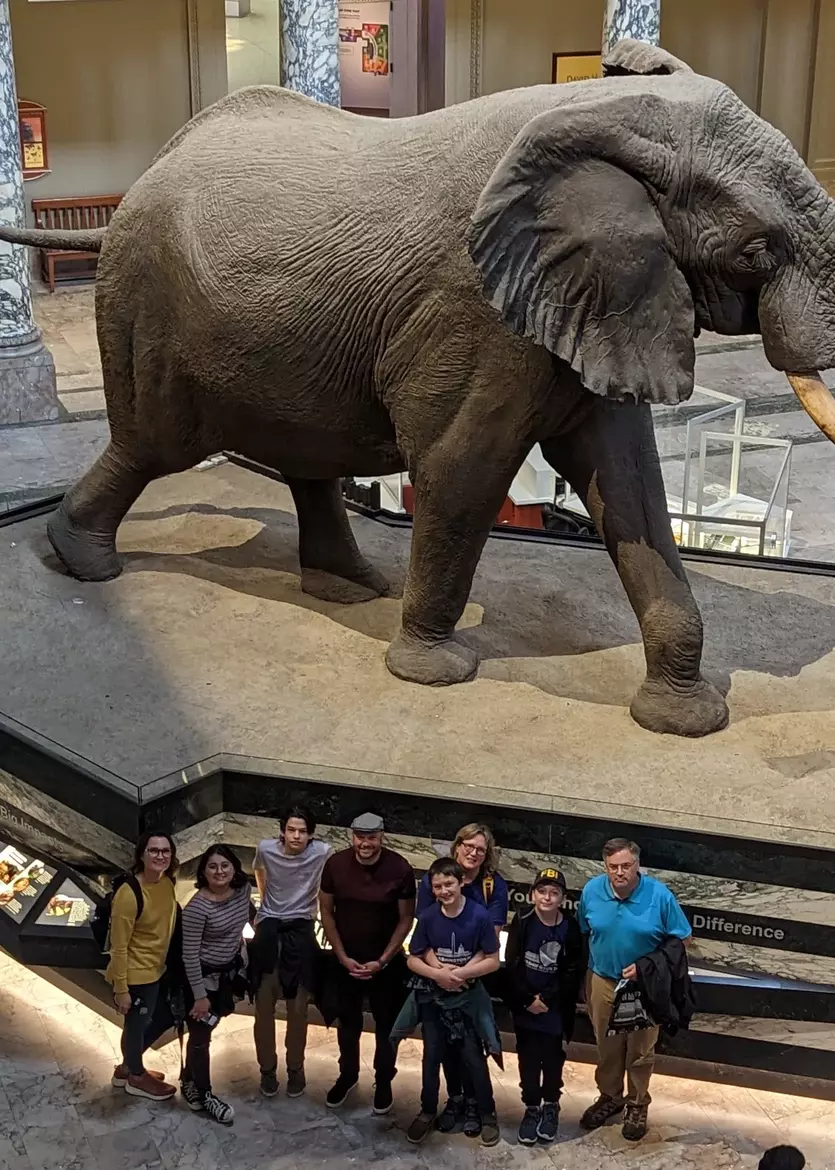 students on a field trip, posing in front of an elephant sculpture