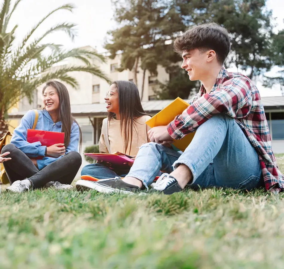 laughing students sitting on the grass