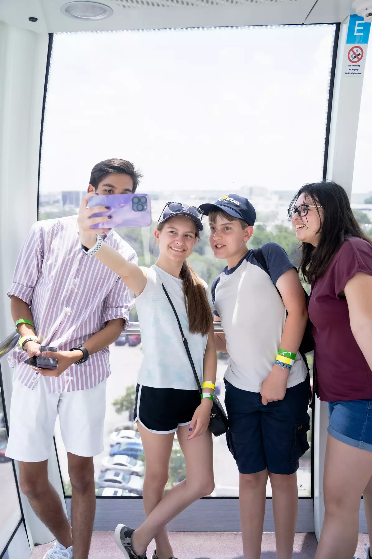 Mixed students taking a selfie in front of a huge window