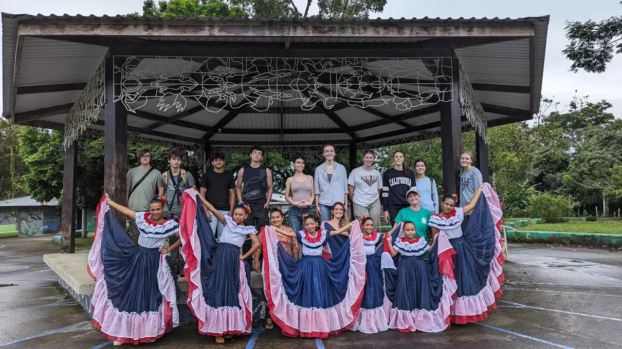 students posing behind young dancers