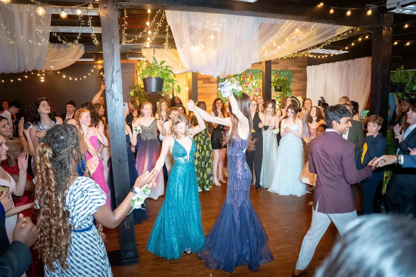 students dancing in formal wear, colorful dresses everywhere